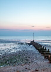 Vertical shot of Sea groynes and reflected light over Hunstanton beach at sunset