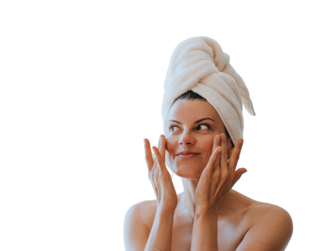 Young adult hispanic woman at bathroom with towel wrapped on head applying cream on face satisfied by spa procedure. Relaxed American female trying new skin care lotion against transparent background