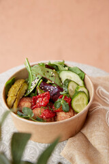 Healthy superfood bowl with vegetables, hummus meatballs, pea sprouts and greens with copy space. Take away food. Plant based diet