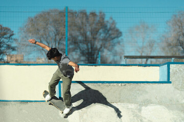 Young skater boy riding in the concrete bowl of skatepark.