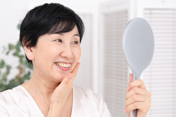 笑顔で鏡を見る女性　ミドル　シニア