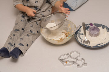 children adding flour to a cake mixture