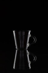 Glass coffee cup on the dark background. Low key photo.