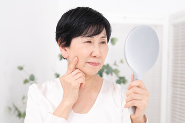 鏡を見て悩む女性　ミドル　シニア