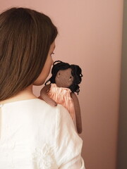 the girl is holding a doll