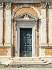 Fototapeta na wymiar Old decorated vintage door with beautiful architectural elements in the historical center of Rome, Italy
