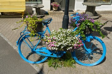 Fototapeta na wymiar Blue bike with flowers in Flekkefjord, Norway
