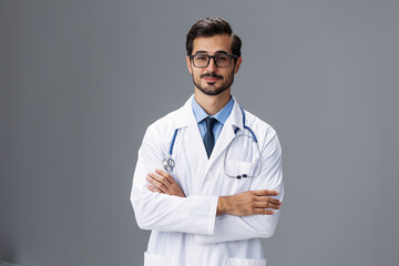 Male doctor in a white coat and glasses for vision and a stethoscope looks at the camera smile with...