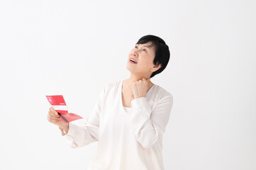 Fototapeta premium 通帳を見て悩む女性