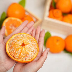 Cut part of orange fruit in human hands