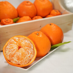 Ripe juicy orange tangerine whole in peel and slices isolated on white background with copy space, flat lay clipping path