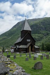 Fototapeta na wymiar Vertical shot of the historic Roldal Stave church near the mountains in Norway