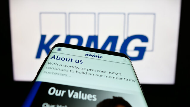 Stuttgart, Germany - 03-17-2023: Smartphone with website of professional services company KPMG on screen in front of business logo. Focus on top-left of phone display.