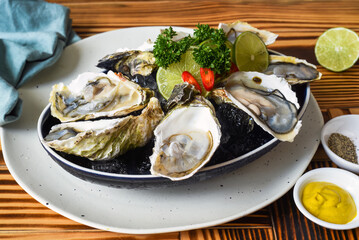 Raw oysters in creamy served with sauces close up