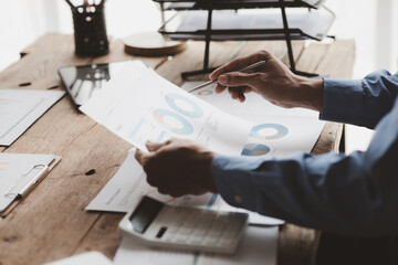 Businessman sits in a private office at his company and is reviewing company financial documents, senior management checking financial information for accuracy. Financial management.