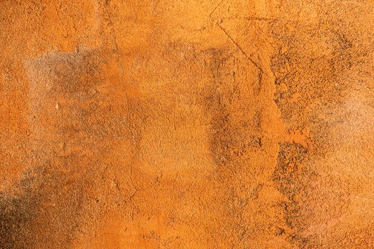 old rough orange plaster wall surface Artistic. Walls and backgrounds Cement brightly colored, old orange walls with black stains, areas caused by moisture. Yellow skin with cracks and scratches.