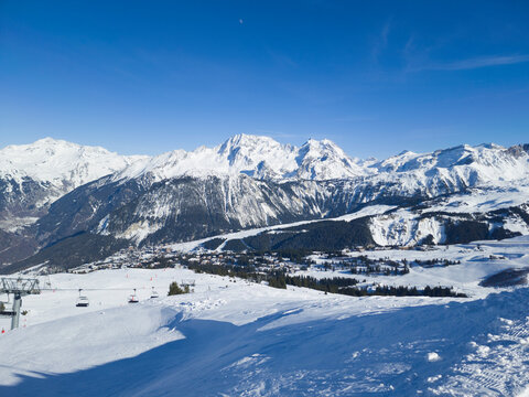 Top view of Courchevel ski area in French alpine Three Valleys resort, with snowy slopes, pine trees, chair lifts .