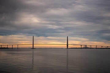 Scenic view of long bridge across the water at sunset
