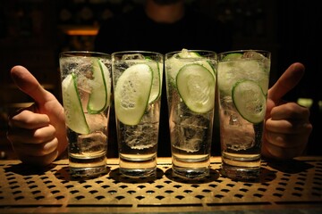 Closeup shot of four glasses of cocktails with cucumbers