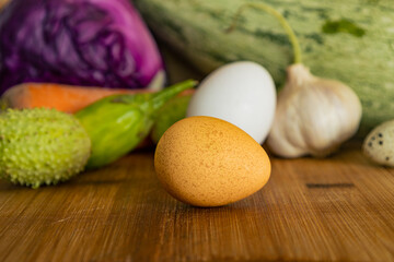 Various colorful vegetables on a rustic light wood background.