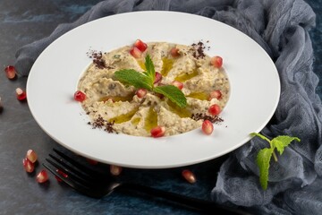 Closeup shot of Mutabal made of grilled eggplant with yogurt on a white plate