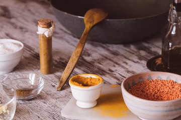 Turmeric, red lentils (dhal) and curry spices on a kitchen table