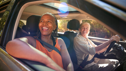 Two Senior Female Friends Enjoying Day Trip Out Driving In Car Together