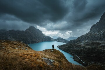 View of the Emosson lake in autumn, with a silhouette standing on a rock in a moody atmosphere