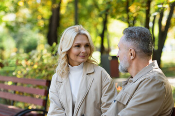 Fototapeta premium Smiling middle aged woman looking at husband in park.