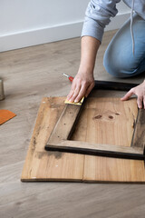 woman's hands doing DIY work in her living room.young woman sanding a wooden piece of furniture

