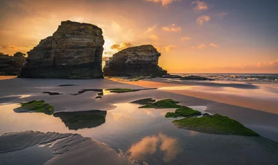 Wall murals Reflection Landscape view of the large rocky formations reflected in the sea at sunset