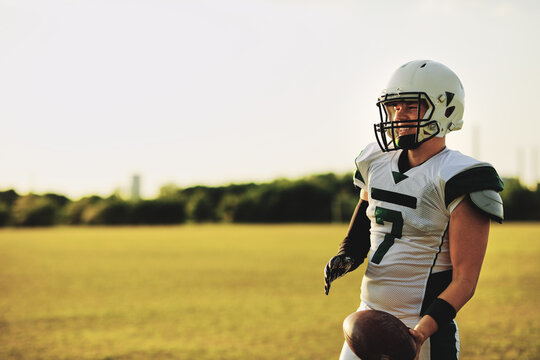 Quarterback standing on a field with a football