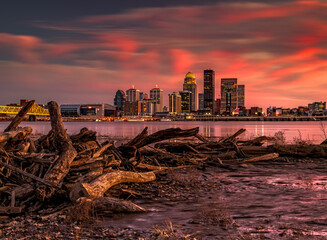 Beautiful shot of chopped tree logs stack against Louisville skyline in Kentucky at pink sunset