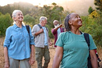 Group Of Senior Friends Enjoying Hiking Through Countryside Together