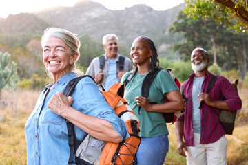 Group Of Senior Friends Enjoying Hiking Through Countryside Together