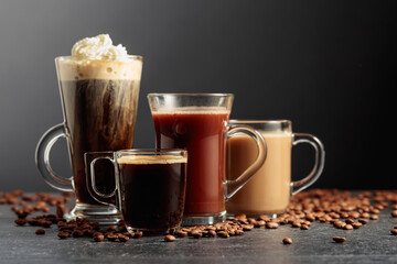 Various coffee and chocolate drinks on a black table.