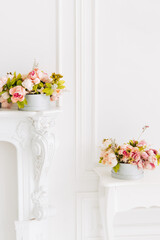 Soft home decor, vase with white and yellow beautiful flowers on a white wall background and on a white table. Interior.