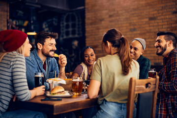 Multiracial group of young happy people gathering in pub.