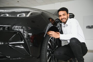 Plakat happy indian man buy new biodiesel eco automobile in lux showroom.