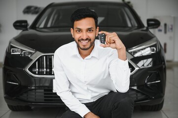 Closeup portrait happy, smiling, young man, buyer showing keys of his new car