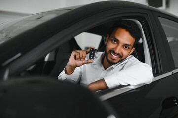 Fototapeta na wymiar Young man sitting inside new car. Smiling