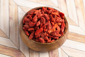 A Bowl of Red Dehydrated Goji Berries in a Wooden Bowl in the Kitchen