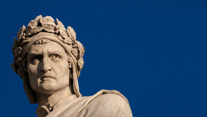 Dante Alighieri the greatest italian poet. Marble statue erected in Florence historical center in 1865 (with blue sky and copy space)