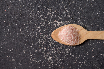 Wooden spoon with pink salt. Close-up view