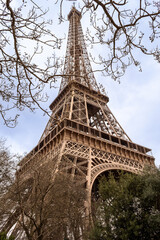 Vertical shot of the Eiffel tower in Paris, France in cloudy sky background