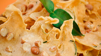 Close up of Crispy peyek with peanuts and green leaf.
