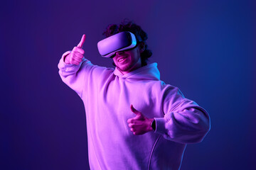 man in vr glasses and sweatshirt plays on blue background.