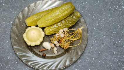 pickles and patisson on a transparent plate on the table