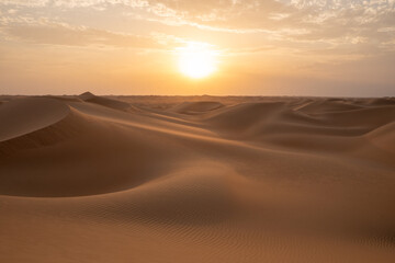 Fototapeta na wymiar Sunset on the dunes in the empty quarter (desert), near Abu Dhabi in the United Arab Emirates.