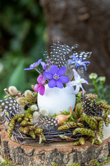 Osterei mit Blüten im Osternest als florale Osterdekoration
